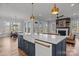 Spacious kitchen featuring a large island, navy cabinets, and an open layout connecting to the dining and living areas at 302 Ambleside Village Ln, Davidson, NC 28036