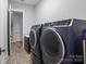 Spacious laundry room featuring front load washer and dryer, wood look tile flooring, and white trim at 302 Ambleside Village Ln, Davidson, NC 28036