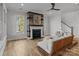 Bright living room with a fireplace and wooden accent wall, alongside comfortable seating and staircase access at 302 Ambleside Village Ln, Davidson, NC 28036