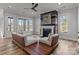Inviting living room featuring wood floors, a rustic fireplace, and ample natural light from large windows at 302 Ambleside Village Ln, Davidson, NC 28036