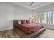 Modern bedroom showcasing a platform bed, tray ceiling, and natural light from the window at 302 Ambleside Village Ln, Davidson, NC 28036