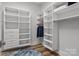 Walk-in closet with custom shelving, drawers, and ample storage space, and wood flooring at 302 Ambleside Village Ln, Davidson, NC 28036
