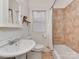 Cozy bathroom featuring tiled walls, a bathtub with shower, and a classic sink at 324 Westwood Ave, Charlotte, NC 28203