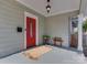 Inviting front porch with a vibrant red door, stylish light fixture, and seating area at 324 Westwood Ave, Charlotte, NC 28203