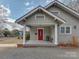 Charming covered front porch featuring a red door, classic columns, and ample space for seating at 324 Westwood Ave, Charlotte, NC 28203