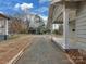 Gravel driveway with access to the street and a view of the home's porch at 324 Westwood Ave, Charlotte, NC 28203