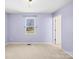 Relaxing bedroom showcasing a view of trees and soft neutral carpets at 341 Massey Deal Rd, Statesville, NC 28625
