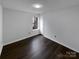 This bedroom features hardwood floors, a neutral color palette, and a window providing natural light at 3632 Farm Lake Sw Dr, Concord, NC 28027