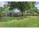 Beautifully landscaped backyard with mature trees, a well-kept lawn, and a cozy gazebo area for outdoor enjoyment at 3714 Conway Ave, Charlotte, NC 28209