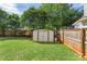 Well-maintained backyard featuring a storage shed, grassy area, and wooden fence for added privacy and convenience at 3714 Conway Ave, Charlotte, NC 28209