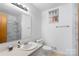 Bathroom with a sink, mirror, toilet, white marble shower and neutral walls at 3714 Conway Ave, Charlotte, NC 28209
