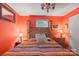 Bedroom with a colorful quilt, wooden headboard, matching nightstands, and orange-painted walls at 3714 Conway Ave, Charlotte, NC 28209