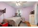 Bedroom with a silver bed frame, grey bedding, painted purple walls, and ceiling fan at 3714 Conway Ave, Charlotte, NC 28209