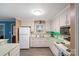 Kitchen featuring white cabinets, modern appliances, green backsplash and tile flooring at 3714 Conway Ave, Charlotte, NC 28209