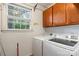 Bright laundry room featuring a window, washer and dryer, and built-in cabinets for additional storage at 3714 Conway Ave, Charlotte, NC 28209