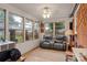 Enclosed sunroom with large windows and a comfortable recliner couch at 3714 Conway Ave, Charlotte, NC 28209
