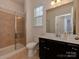Bathroom featuring a glass-enclosed shower and a vanity with a sink and ample lighting at 4856 Pepper Dr, Harrisburg, NC 28075