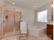 Bright bathroom featuring a large soaking tub and a glass-enclosed shower at 4856 Pepper Dr, Harrisburg, NC 28075