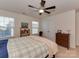 Carpeted bedroom with ceiling fan, two windows, a queen bed, and a dresser at 4856 Pepper Dr, Harrisburg, NC 28075