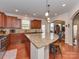 A kitchen with granite countertops, wood cabinets, a stainless steel range, and an island open to the dining area at 4856 Pepper Dr, Harrisburg, NC 28075