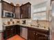 Modern kitchen with stainless steel appliances, granite countertops, dark cabinets, and a stainless sink at 4856 Pepper Dr, Harrisburg, NC 28075