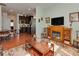 View of an open-concept living room featuring a cozy fireplace, adjacent kitchen, and hardwood flooring at 4856 Pepper Dr, Harrisburg, NC 28075