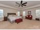 Spacious primary bedroom with a seating area, a queen bed, and plush carpet at 4856 Pepper Dr, Harrisburg, NC 28075