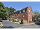 Stately three-story brick townhome featuring multiple windows and attached garages, set against lush greenery under a clear sky at 4860 S Hill View Dr, Charlotte, NC 28210