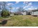 Grassy backyard featuring a fenced perimeter and detached outbuilding with horizontal siding at 520 Rogers St, Albemarle, NC 28001