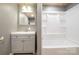Well-lit bathroom with a white shower and vanity with a gray cabinet at 520 Rogers St, Albemarle, NC 28001
