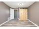 Bedroom featuring light gray walls, wood-look floors, and a sliding barn wood closet door at 520 Rogers St, Albemarle, NC 28001