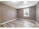 Bedroom featuring light gray walls, wood-look floors, and a large window at 520 Rogers St, Albemarle, NC 28001