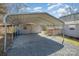 Carport providing covered parking with a gravel driveway near the home and additional storage building at 520 Rogers St, Albemarle, NC 28001
