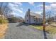 View of the house with gravel driveway and detached carport, blending convenience and charm at 520 Rogers St, Albemarle, NC 28001