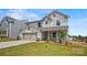 Inviting two-story home with stone detailing, a two-car garage, and green lawn at 5227 Hatcher Creek Rd # 43, Charlotte, NC 28215