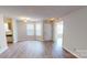 Sun-lit living area with wood-look laminate flooring, neutral walls, and a view of the front entrance at 5921 Amity Springs Dr, Charlotte, NC 28212