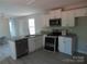 Open kitchen with breakfast bar featuring stainless appliances, white cabinets, and modern design at 635 Acre Ct, York, SC 29745