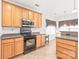 Functional kitchen featuring wood cabinets, black appliances, and a cozy breakfast nook area at 696 Yvonne Sw Dr, Concord, NC 28027