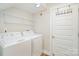 Laundry room with white washer, dryer, wire shelving, and door at 7413 Adirondack Dr, Denver, NC 28037