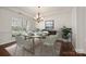 Elegant dining room with modern chandelier, hardwood floors, and a large window providing natural light at 8025 Penman Springs Dr, Waxhaw, NC 28173
