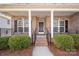 Inviting front porch featuring brickwork and elegant black iron railings, leading to the home's entrance at 8025 Penman Springs Dr, Waxhaw, NC 28173
