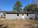 Backyard view of the gray house; features a door and windows overlooking the green lawn at 811 Sanford St, Marshville, NC 28103
