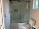 Bathroom featuring bathtub with glass doors and adjacent toilet at 811 Sanford St, Marshville, NC 28103