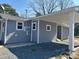 The gray house features white trim around the windows and on the carport's pillars at 811 Sanford St, Marshville, NC 28103