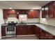 Modern kitchen with stainless steel appliances, dark wood cabinets, and gray countertops at 811 Sanford St, Marshville, NC 28103