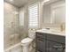 Modern bathroom featuring a glass-enclosed shower, stylish vanity, and marble tile at 8328 Victoria Lake Dr, Waxhaw, NC 28173