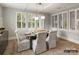 Dining room with a wooden table, six chairs, and a view of the outside through shuttered windows at 8328 Victoria Lake Dr, Waxhaw, NC 28173
