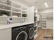 Well-organized laundry room with modern washer and dryer, ample storage, and convenient shelving units at 8328 Victoria Lake Dr, Waxhaw, NC 28173