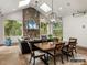Bright sunroom with a stone fireplace, skylights, and a dining area, perfect for relaxation and entertaining at 8328 Victoria Lake Dr, Waxhaw, NC 28173