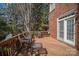 Inviting brick home features a spacious wooden deck, complete with stylish wicker furniture and nature views at 9423 Belmont Ln, Marvin, NC 28173